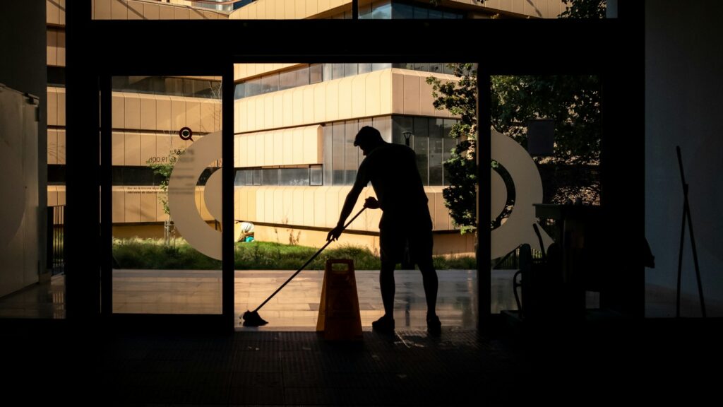 silhouette of man standing near glass window during daytime